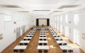 Großer Seminarraum mit Tischen und Podium für Veranstaltungen.