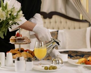 Ein Kellner serviert Frühstück im Hotelzimmer.